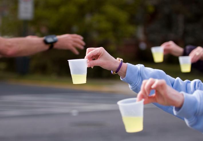 volunteers handing nuun cups to a racer