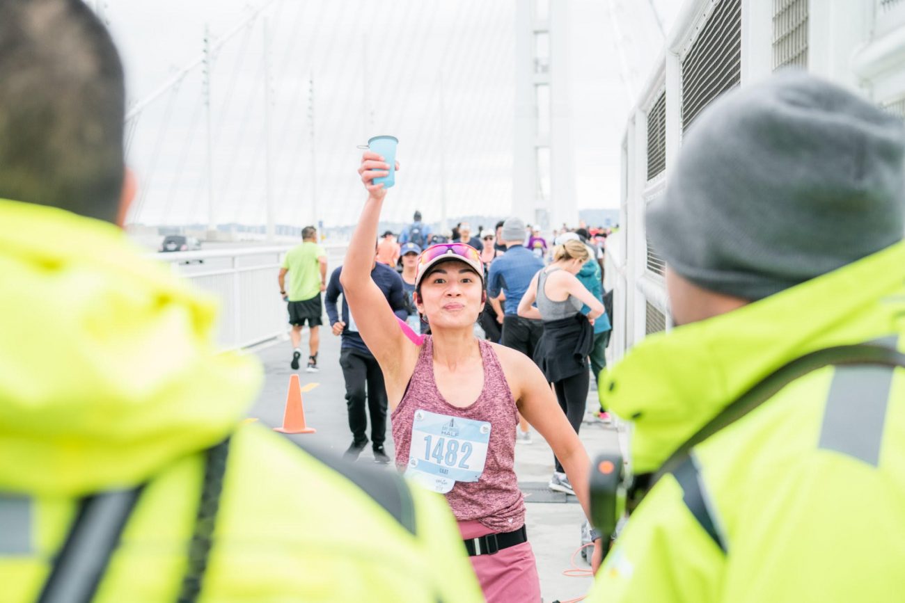 runner holding up a hydration cup during a race