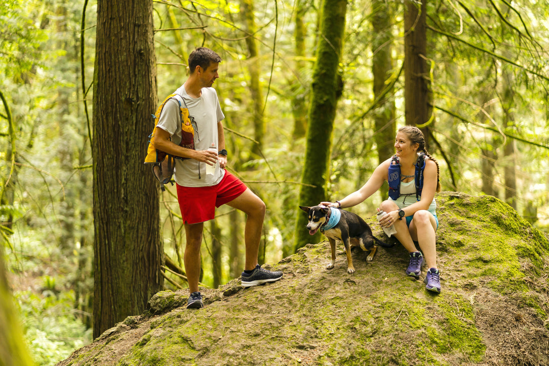 Two people trail running with a dog