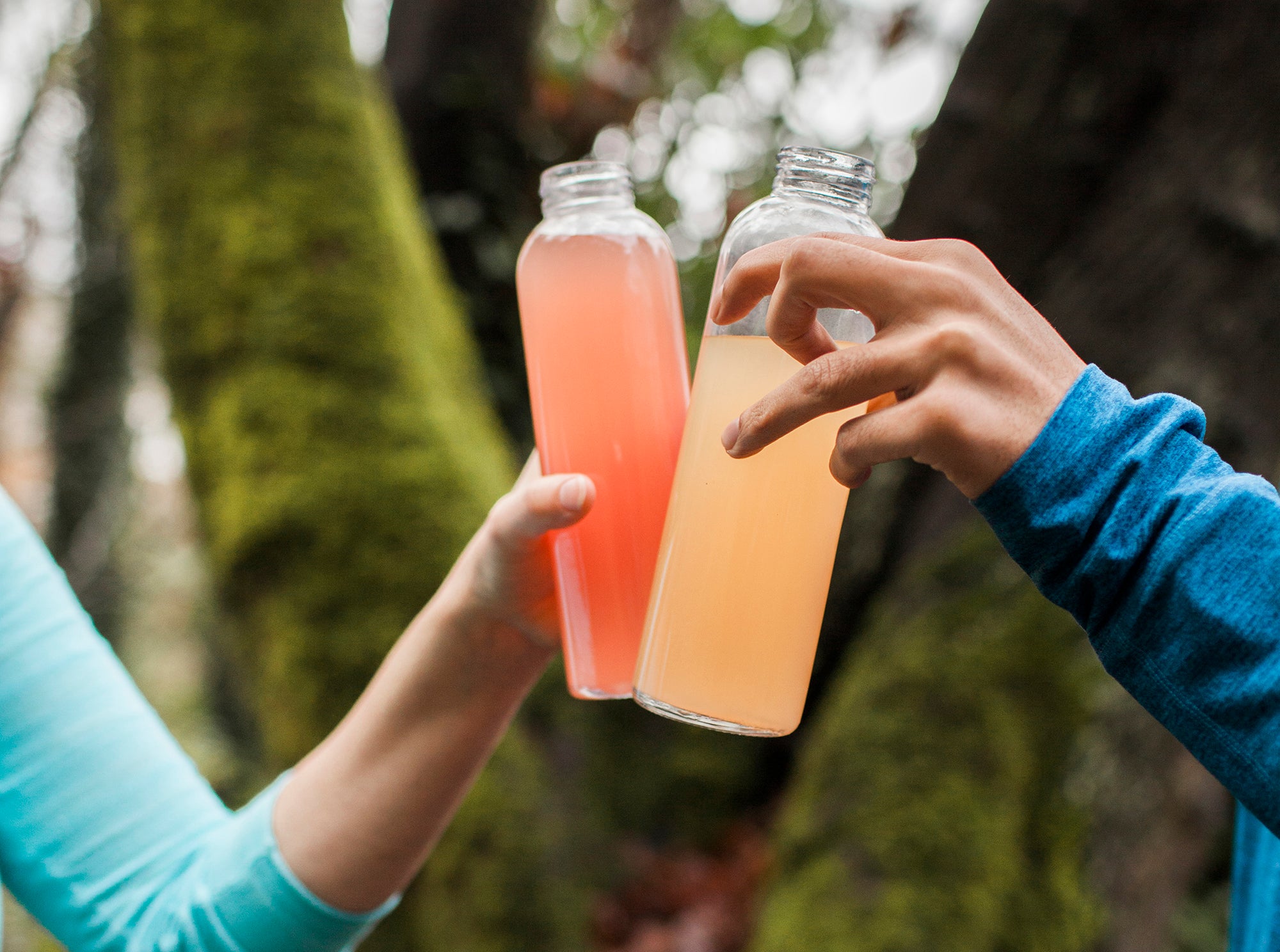 Two people clinking bottles of Nuun