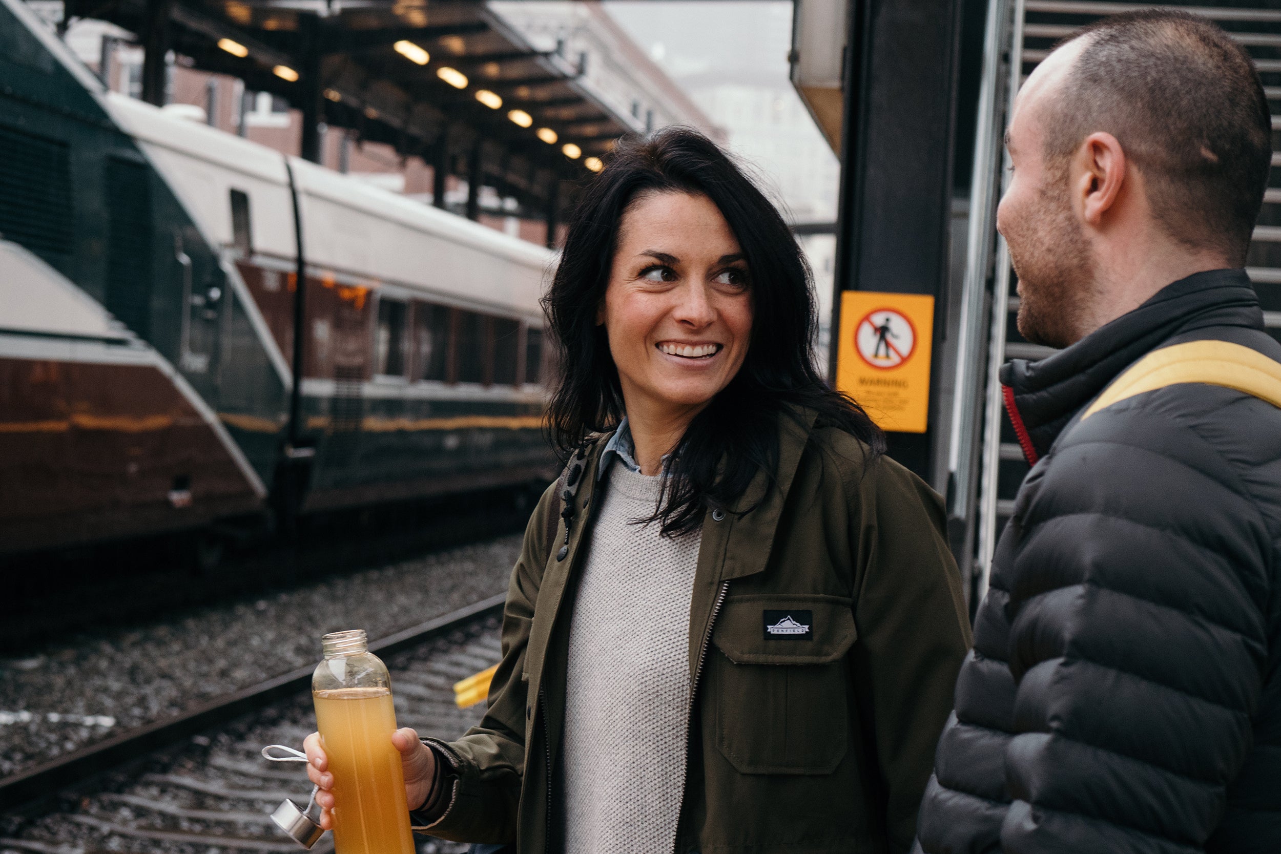 Two people drinking Nuun Immunity at a train station