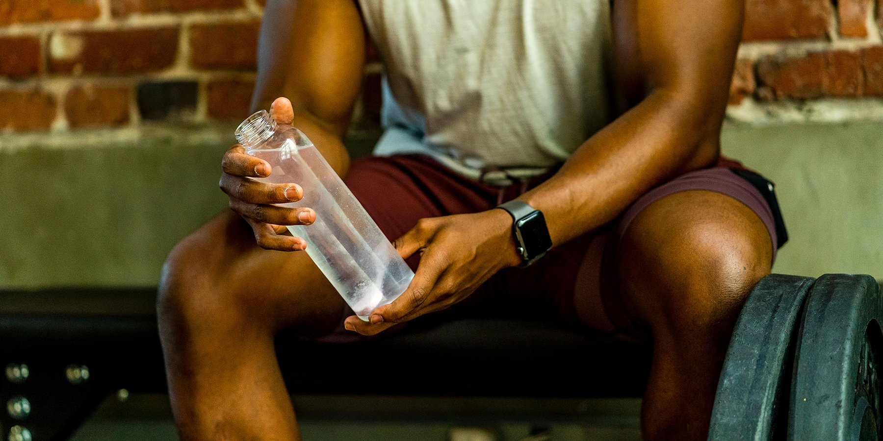 Person holding a water bottle during a workout