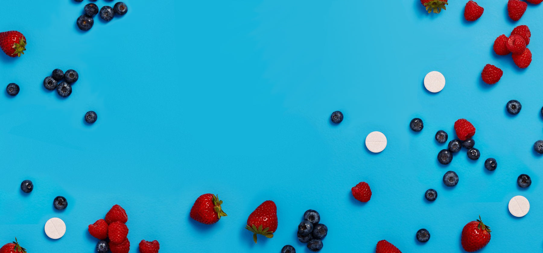 Tablets and fresh fruit on a blue background