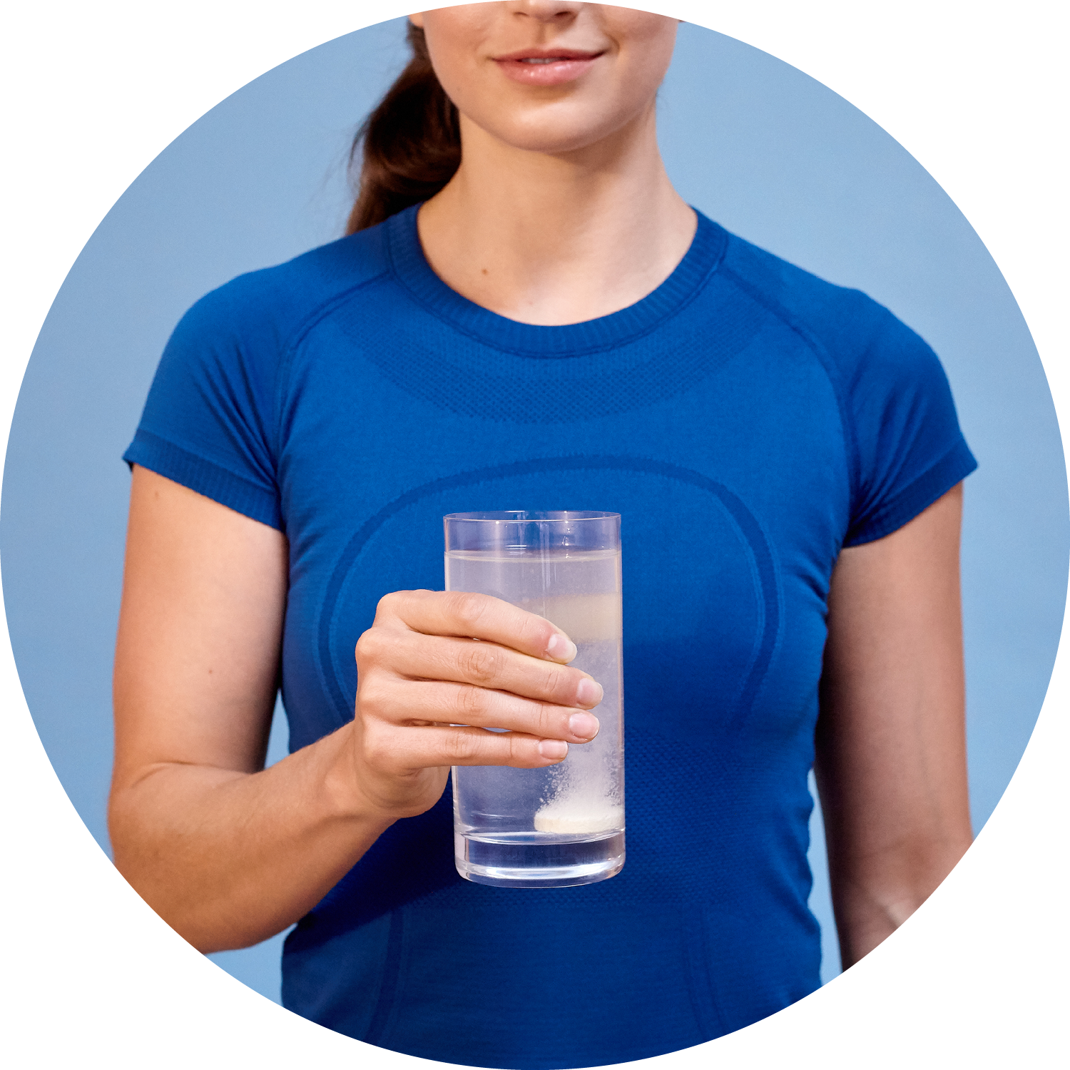 A person holding a glass with a dissolving tablet